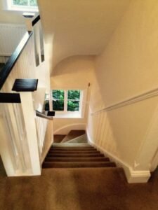 Stairwell Redecoration with White Balusters and Dark Handrails